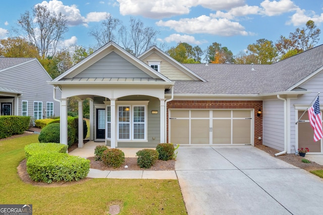 view of front of home featuring a porch, a garage, and a front lawn