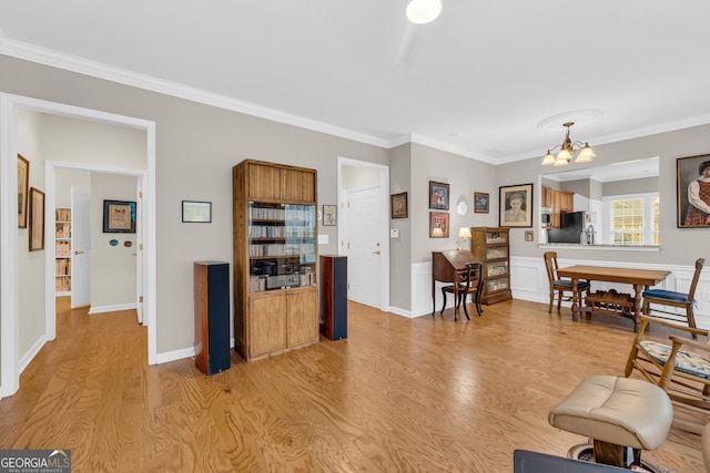 living room with light hardwood / wood-style floors, ornamental molding, and a notable chandelier