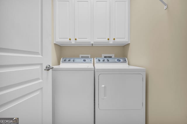 washroom featuring cabinets and washing machine and dryer