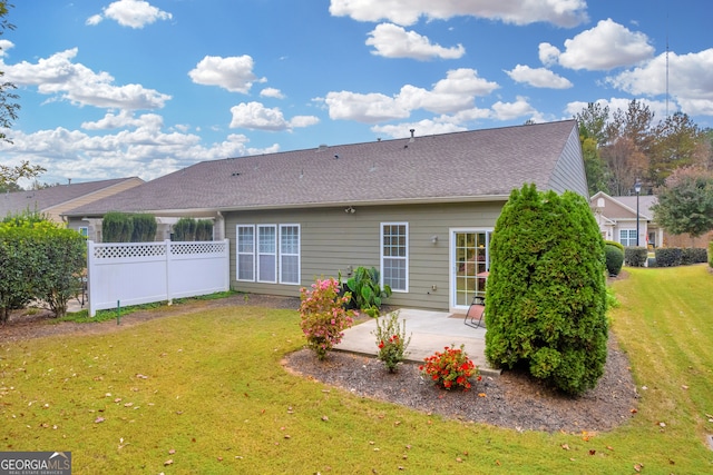 back of property featuring a patio area and a yard