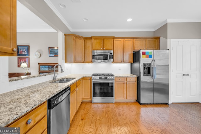 kitchen featuring sink, crown molding, light hardwood / wood-style floors, light stone counters, and stainless steel appliances