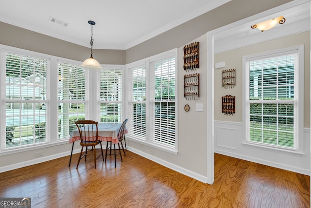 dining space with crown molding and hardwood / wood-style floors