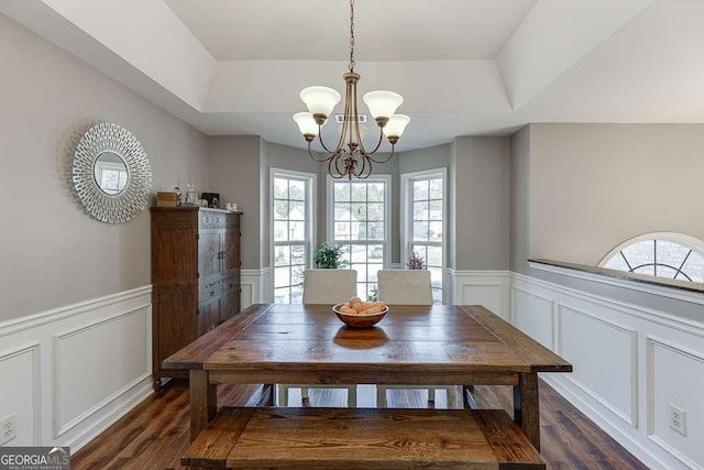 dining area with dark hardwood / wood-style flooring and a notable chandelier