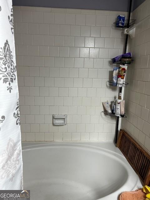 bathroom with shower / bath combo with shower curtain