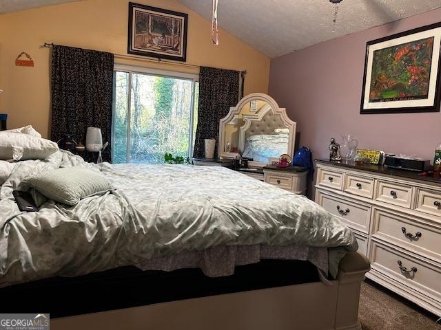 bedroom featuring vaulted ceiling and dark colored carpet