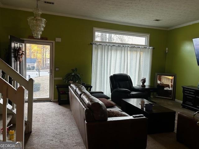 living room with light carpet, visible vents, ornamental molding, and a textured ceiling