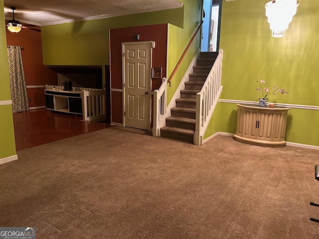 interior space featuring ornamental molding, carpet, baseboards, and stairs