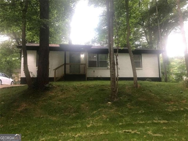 rear view of house featuring a lawn