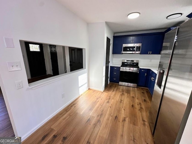 interior space with blue cabinetry, light hardwood / wood-style flooring, and stainless steel appliances