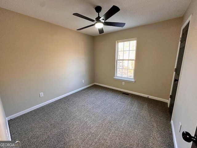 carpeted spare room featuring ceiling fan