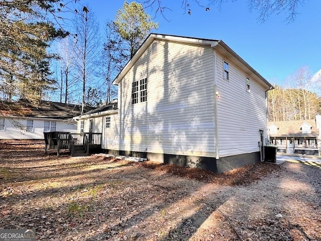 view of property exterior featuring cooling unit and a deck