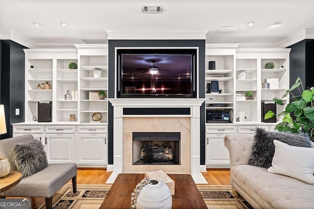 living room featuring a fireplace, light hardwood / wood-style flooring, and crown molding