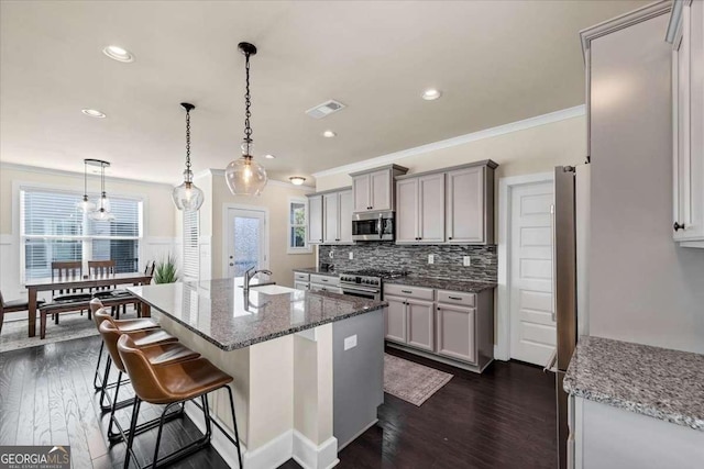 kitchen featuring dark hardwood / wood-style floors, ornamental molding, sink, and appliances with stainless steel finishes