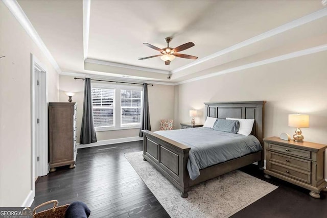 bedroom featuring a tray ceiling, ceiling fan, dark hardwood / wood-style flooring, and ornamental molding