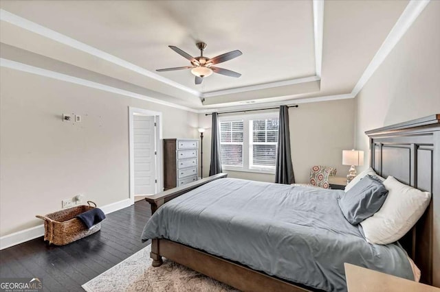 bedroom featuring a tray ceiling, ceiling fan, crown molding, and dark wood-type flooring