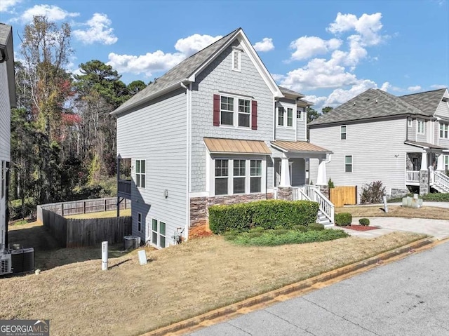 front of property featuring cooling unit and a front lawn