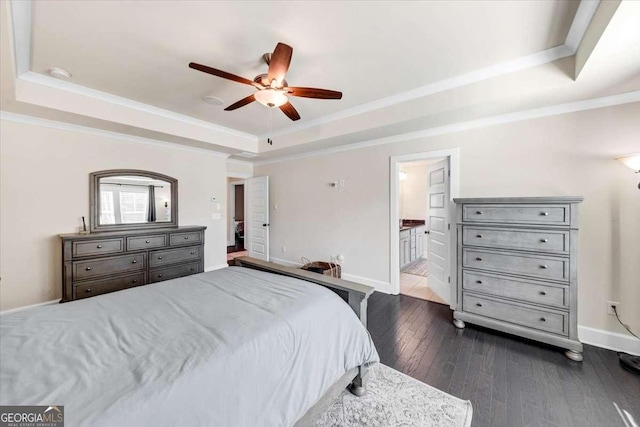 bedroom with ceiling fan, a raised ceiling, wood-type flooring, and connected bathroom