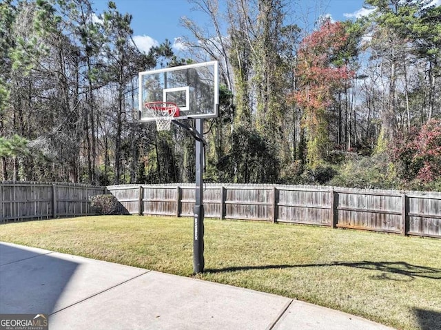 view of yard featuring basketball hoop