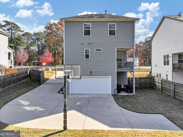 back of house with a garage and a balcony