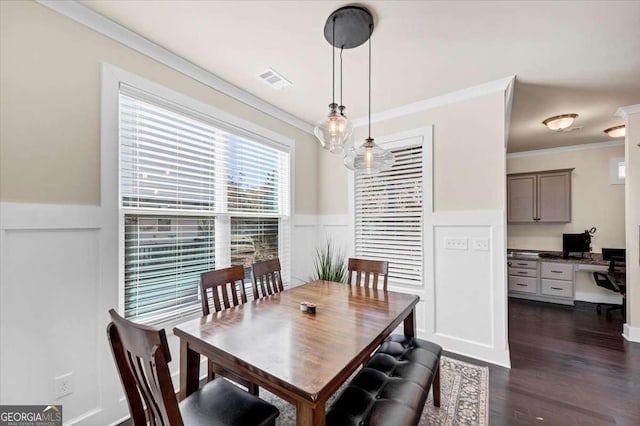 dining space with dark wood-type flooring and ornamental molding