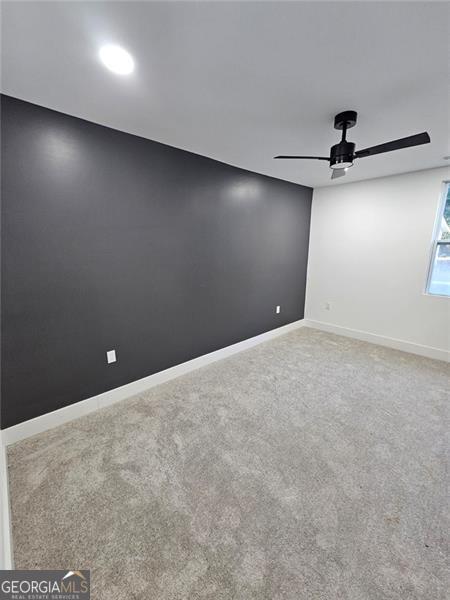 empty room featuring carpet flooring and ceiling fan