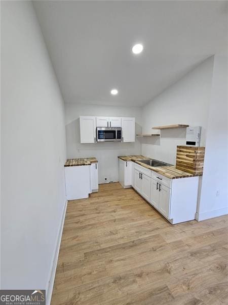 kitchen with white cabinetry and light hardwood / wood-style flooring