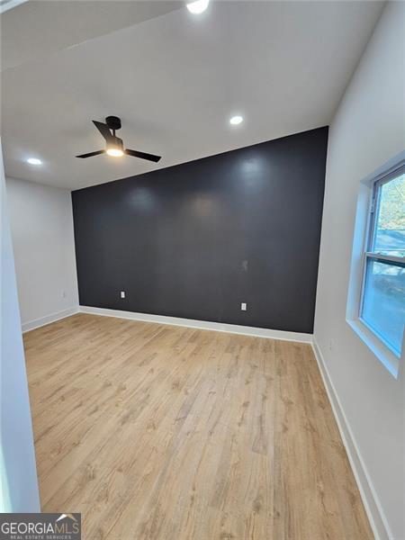 empty room featuring ceiling fan and light hardwood / wood-style floors