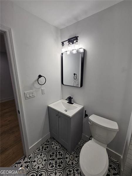 bathroom featuring tile patterned floors, vanity, and toilet