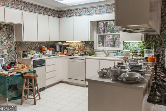 kitchen featuring dishwasher, white cabinets, light tile patterned floors, and sink