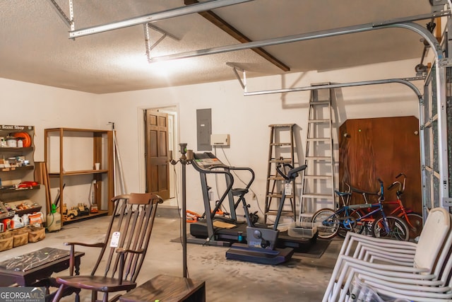 exercise room featuring electric panel and a textured ceiling