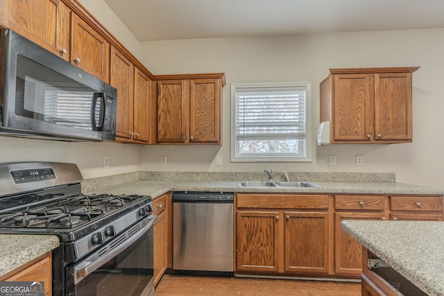 kitchen with light stone countertops, sink, and stainless steel appliances