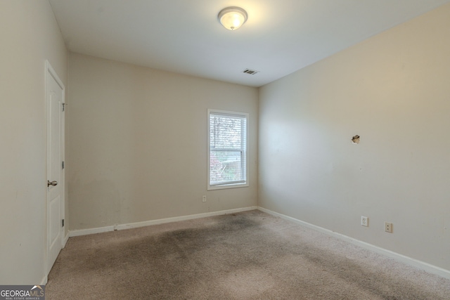 spare room featuring light colored carpet