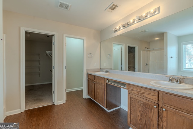 bathroom with hardwood / wood-style floors, vanity, and walk in shower