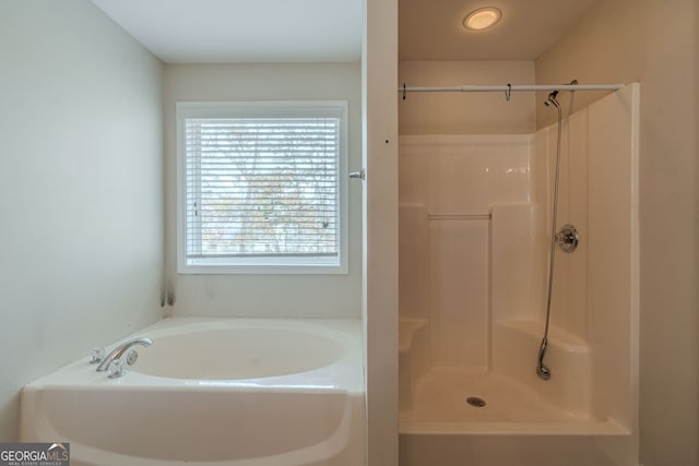 bathroom featuring shower with separate bathtub