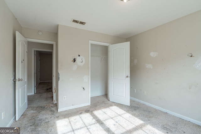 unfurnished bedroom featuring light carpet and a closet