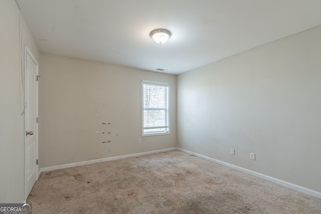 spare room featuring light colored carpet