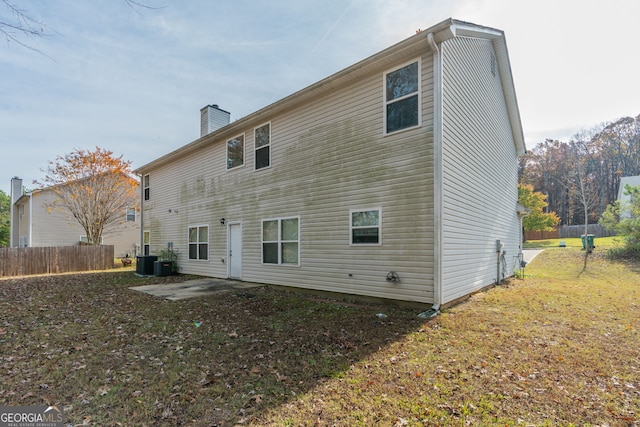 rear view of house featuring cooling unit, a patio area, and a yard