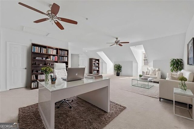 home office with light carpet, ceiling fan, and vaulted ceiling