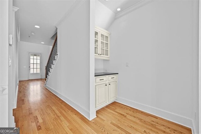 hallway featuring crown molding and light hardwood / wood-style floors