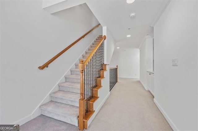 staircase featuring carpet and ornamental molding