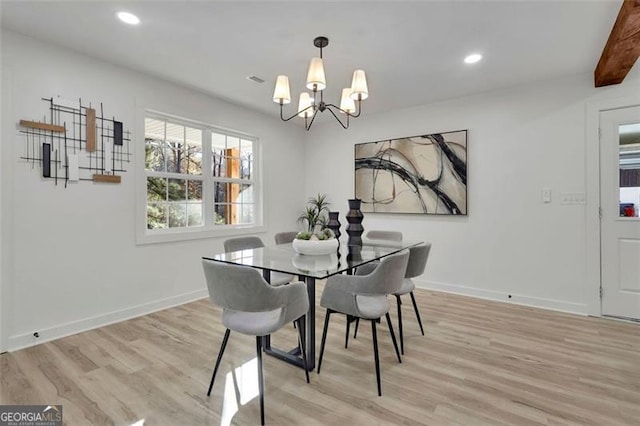 dining area with beamed ceiling, light wood-type flooring, and an inviting chandelier