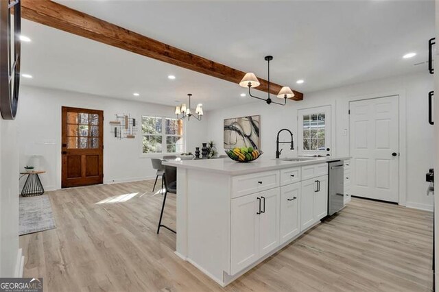 kitchen with dishwasher, a center island with sink, white cabinets, sink, and decorative light fixtures