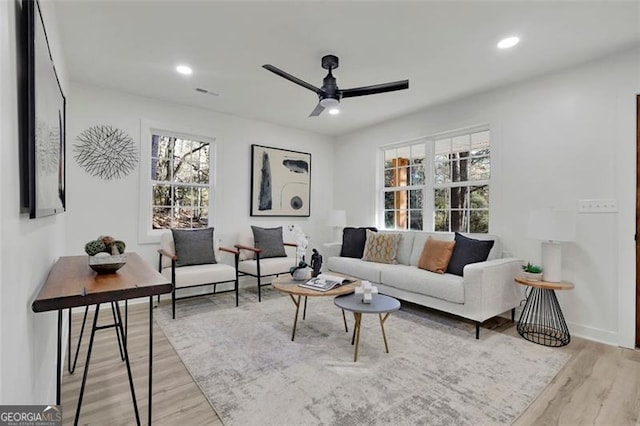 living room with light hardwood / wood-style floors and ceiling fan