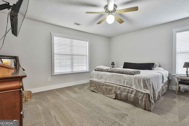 carpeted bedroom with ceiling fan and a textured ceiling