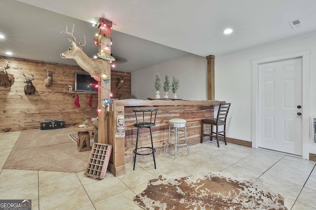 kitchen with wood walls and light tile patterned floors