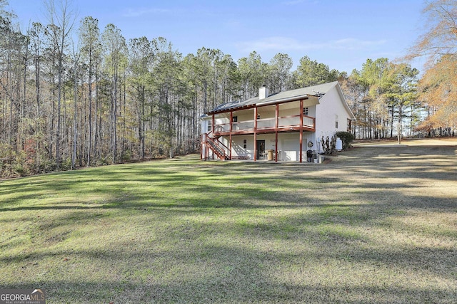 back of property featuring a lawn and a wooden deck