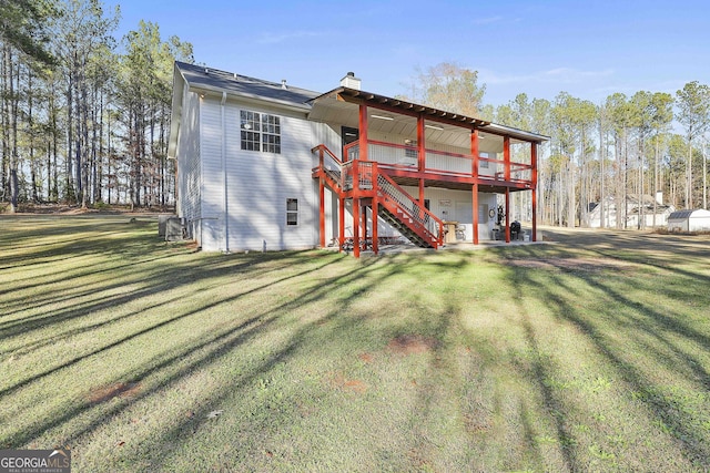 rear view of property featuring a deck and a lawn