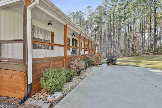 view of side of home featuring a lawn and covered porch