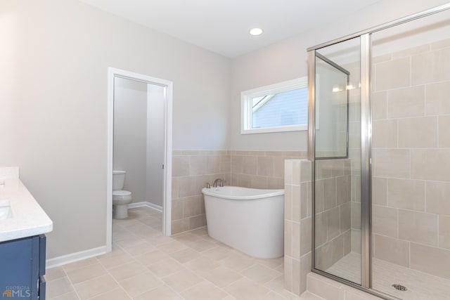 full bathroom featuring tile patterned flooring, toilet, vanity, independent shower and bath, and tile walls