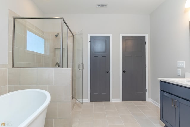 bathroom with tile patterned flooring, vanity, and independent shower and bath